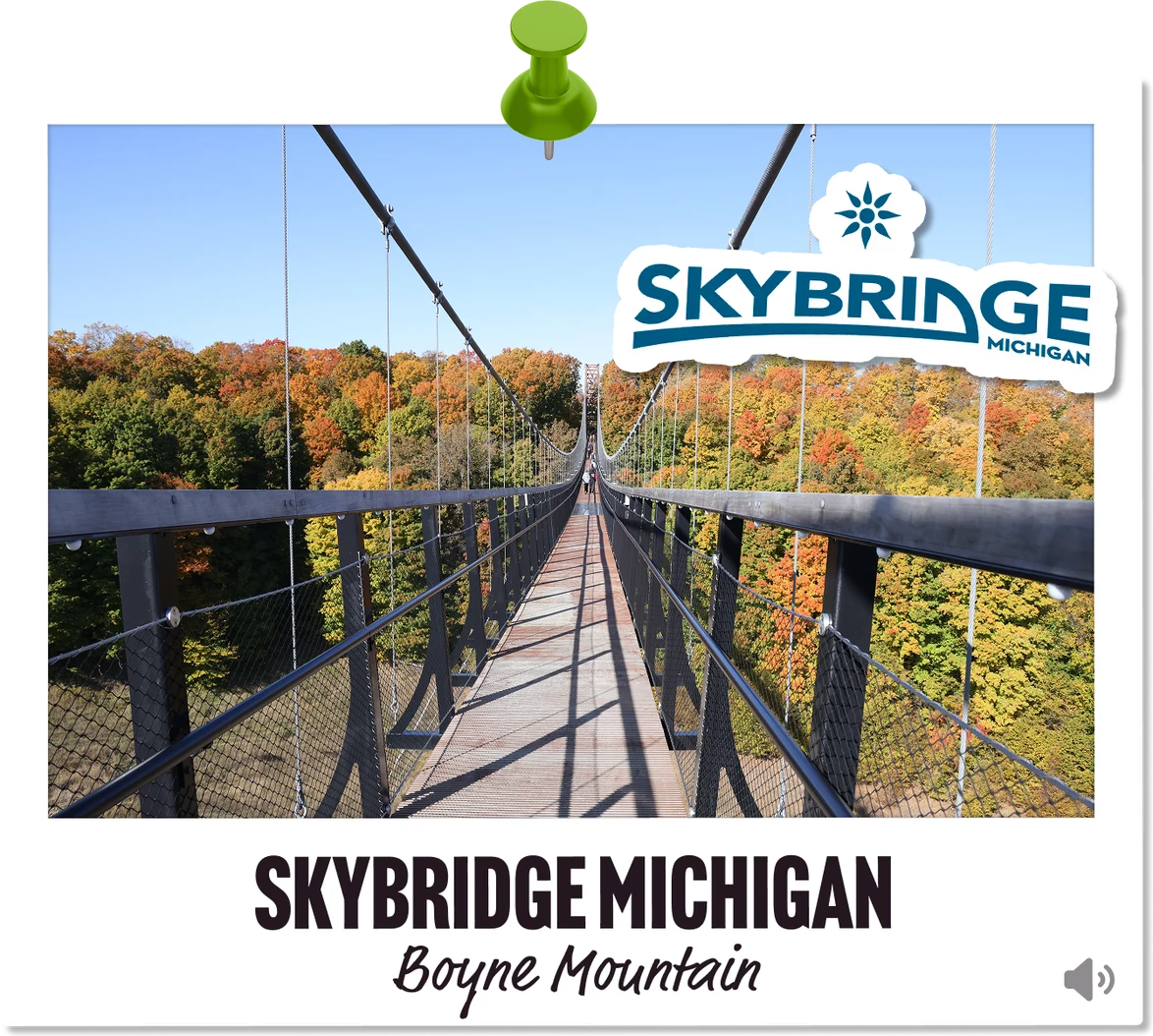 A photo looking down the length of the skybridge in Boyne Mountain — marked with the Skybridge Michigan logo.