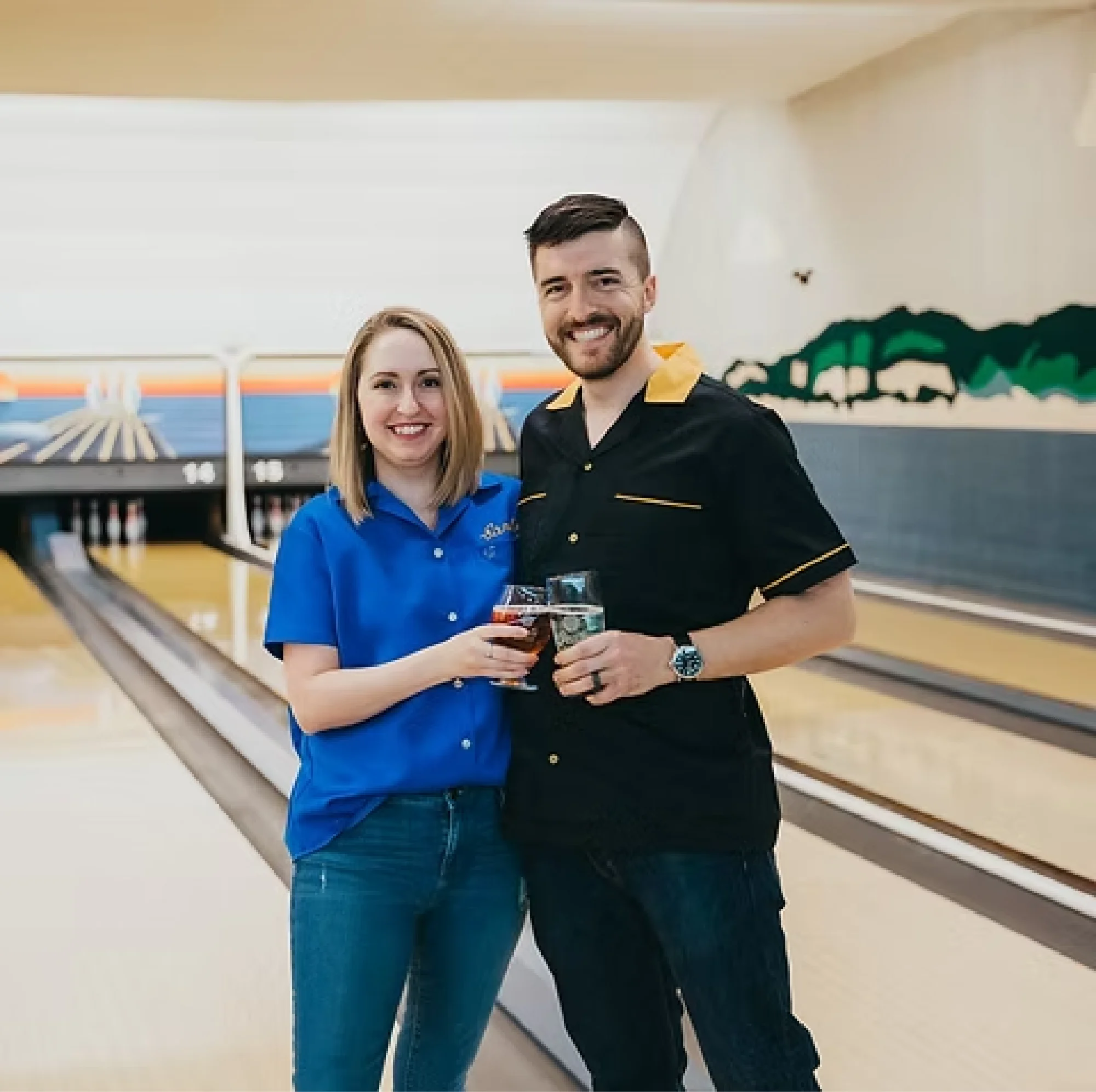 Dan and Leah Peat smiling as they clink glasses